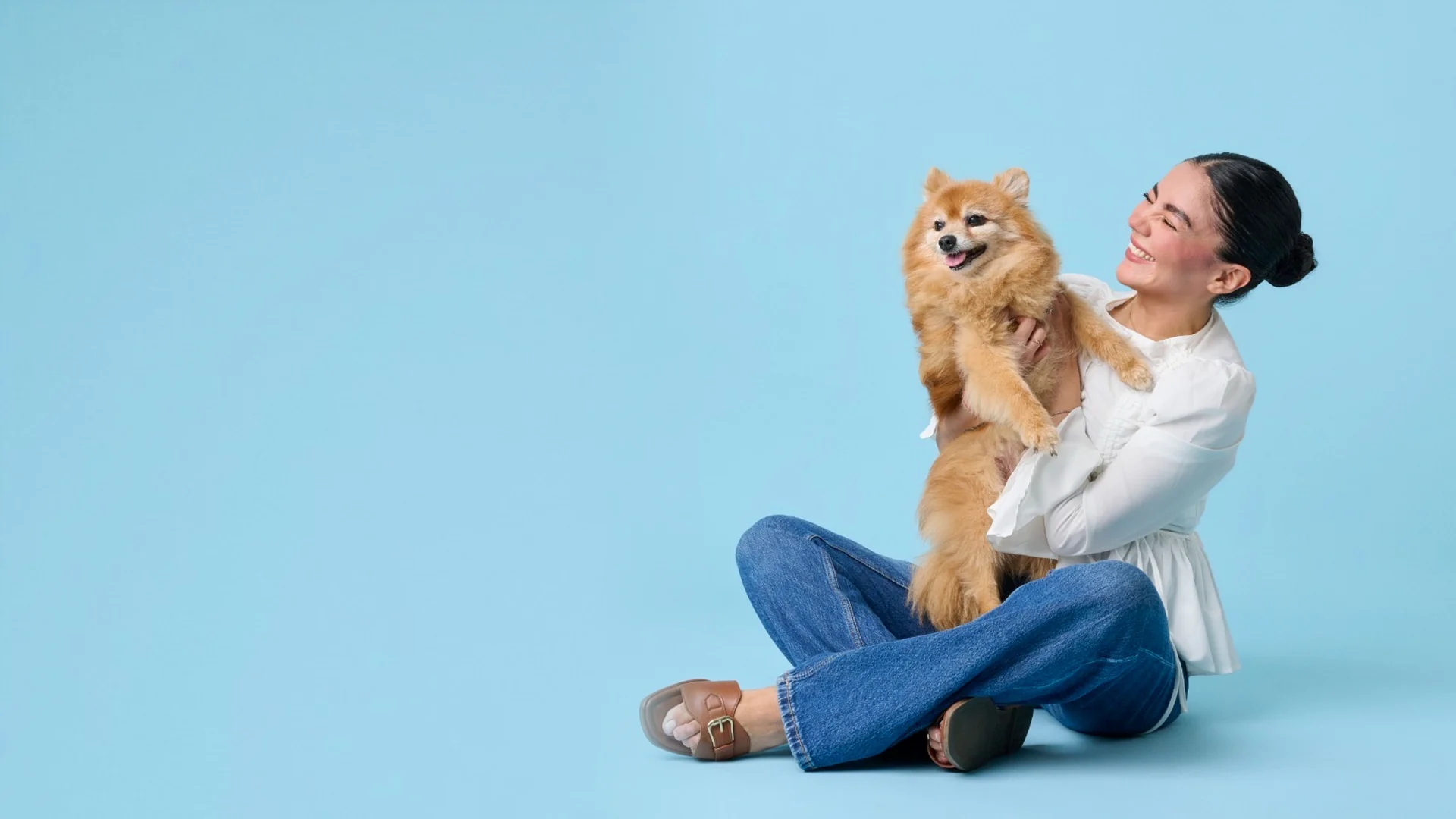 A pet owner with her dog in NovaPet’s blue studio setting
